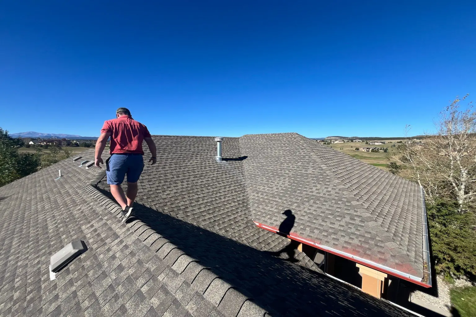 Roofer inspecting residential roof in colorado springs