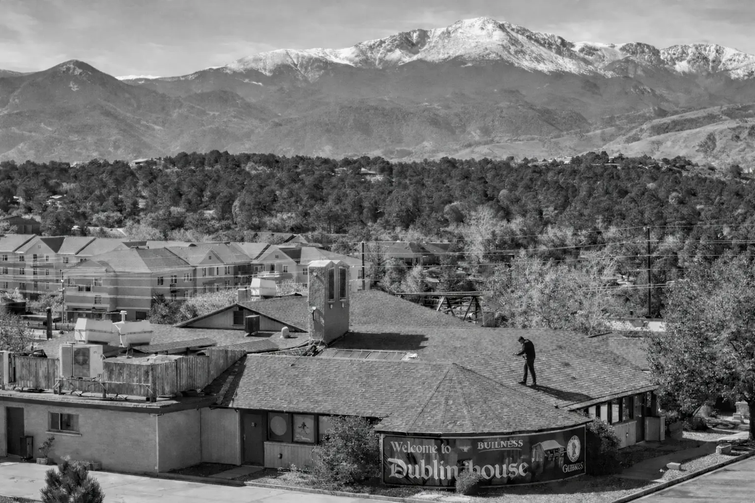 Commercial roof inspector examining shingled roof in Colorado Springs
