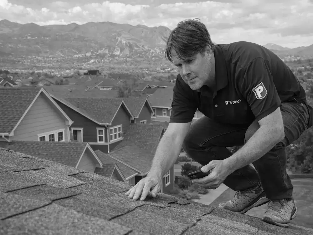Professional roof inspector documenting storm damage on Colorado Springs residential property for insurance claim