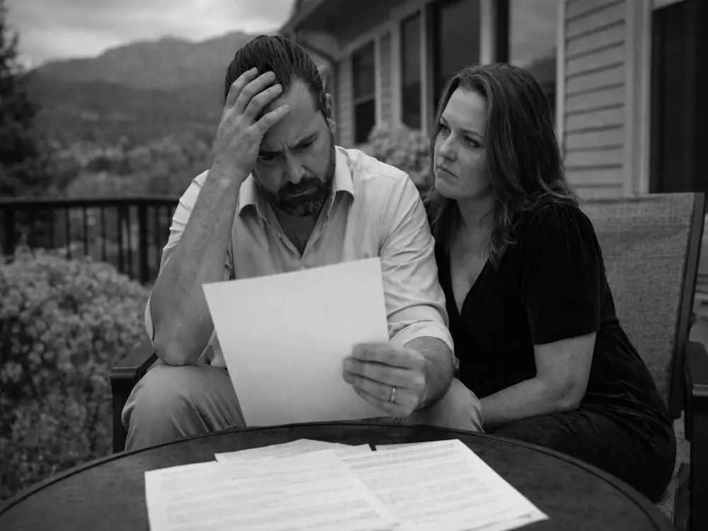 Frustrated Colorado Springs homeowner reviewing denied or lowball roof insurance claim settlement offer